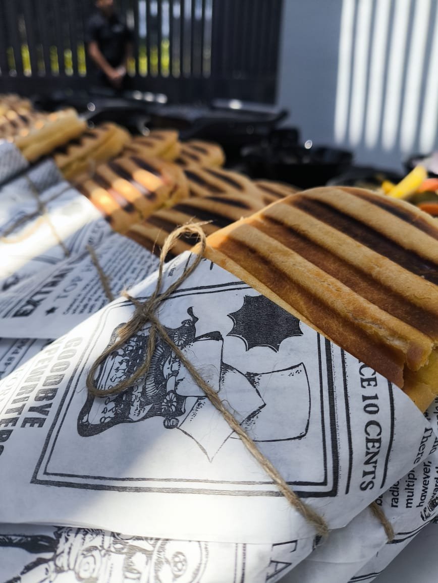 Spider perched on a bat illustration printed on newspaper, with wooden rulers and crates in the background